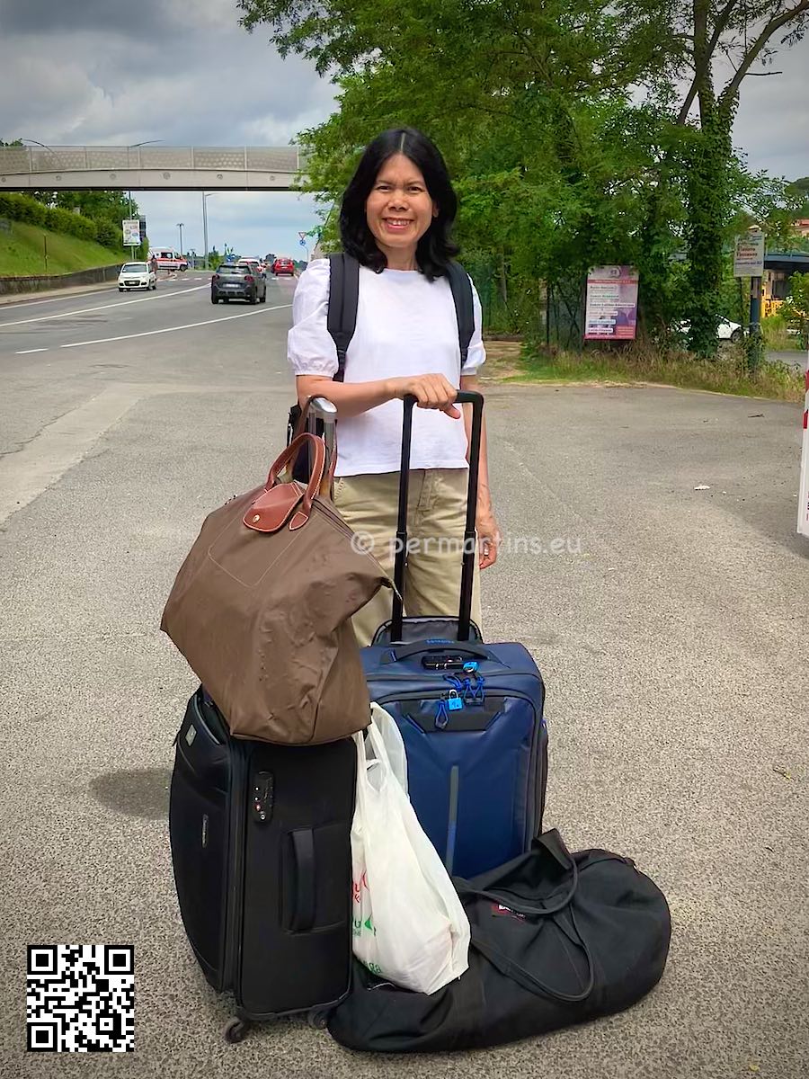 Italy Siena woman with luggage by the road.