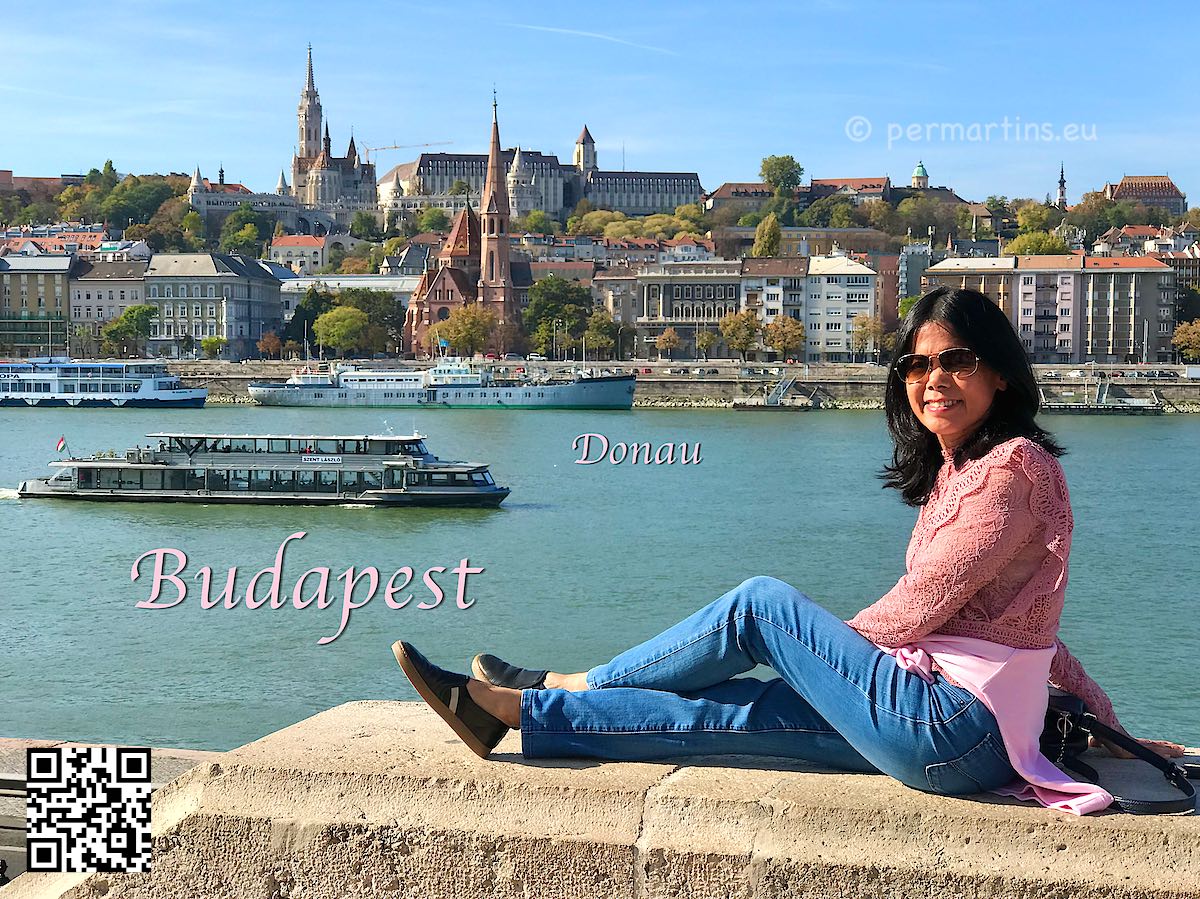 Hungary Budapest woman sitting an a stone wall with the Danube in the background boat old town 