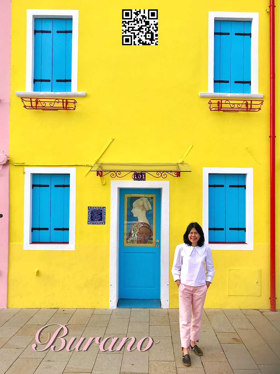 Italy Venice Burano women in front of yellow building with blue window shutters and door