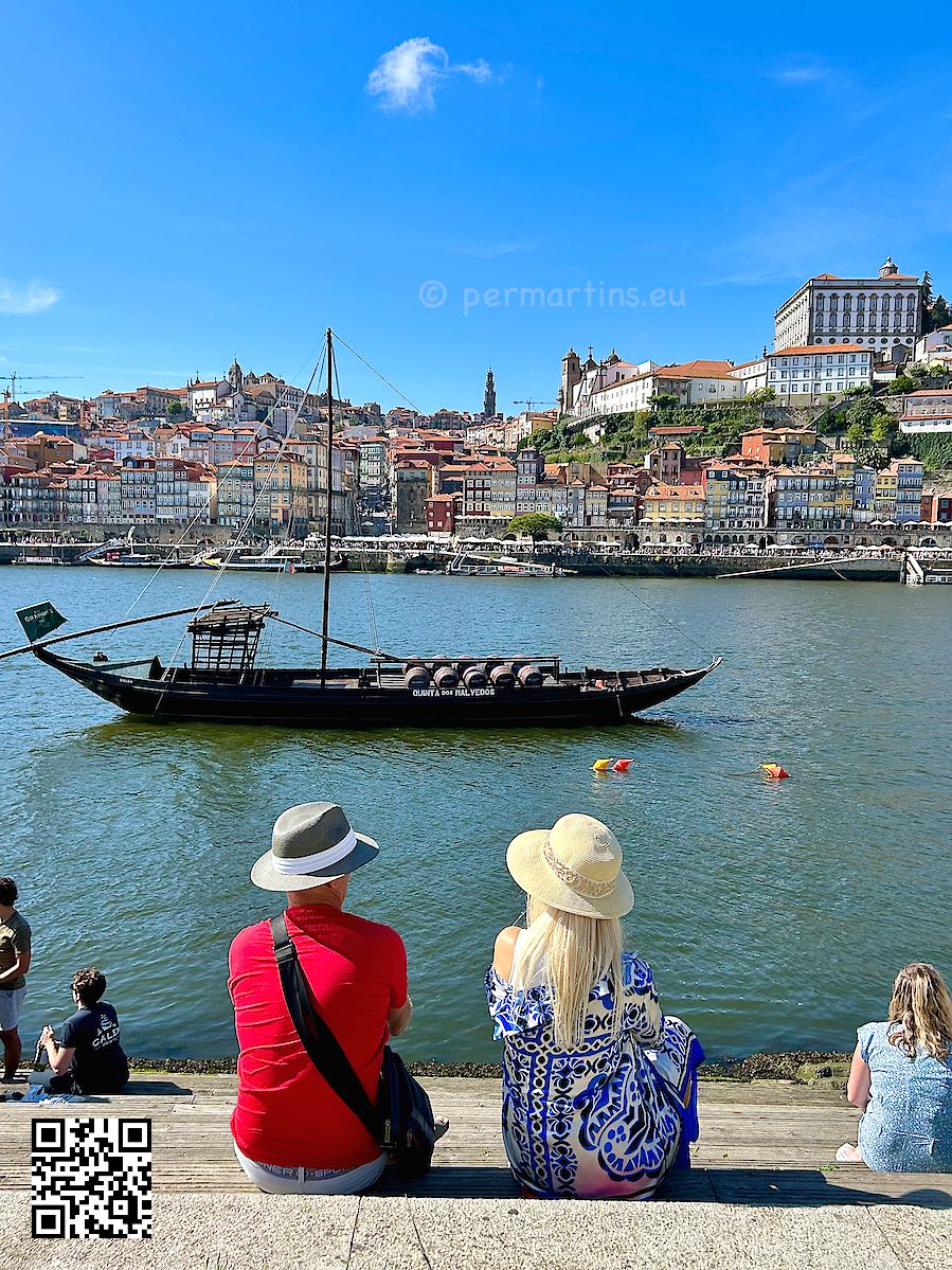Portugal at Vila Nova de Gaia view towards Porto traditional Port wine boat on the Douro couple with hats sitting