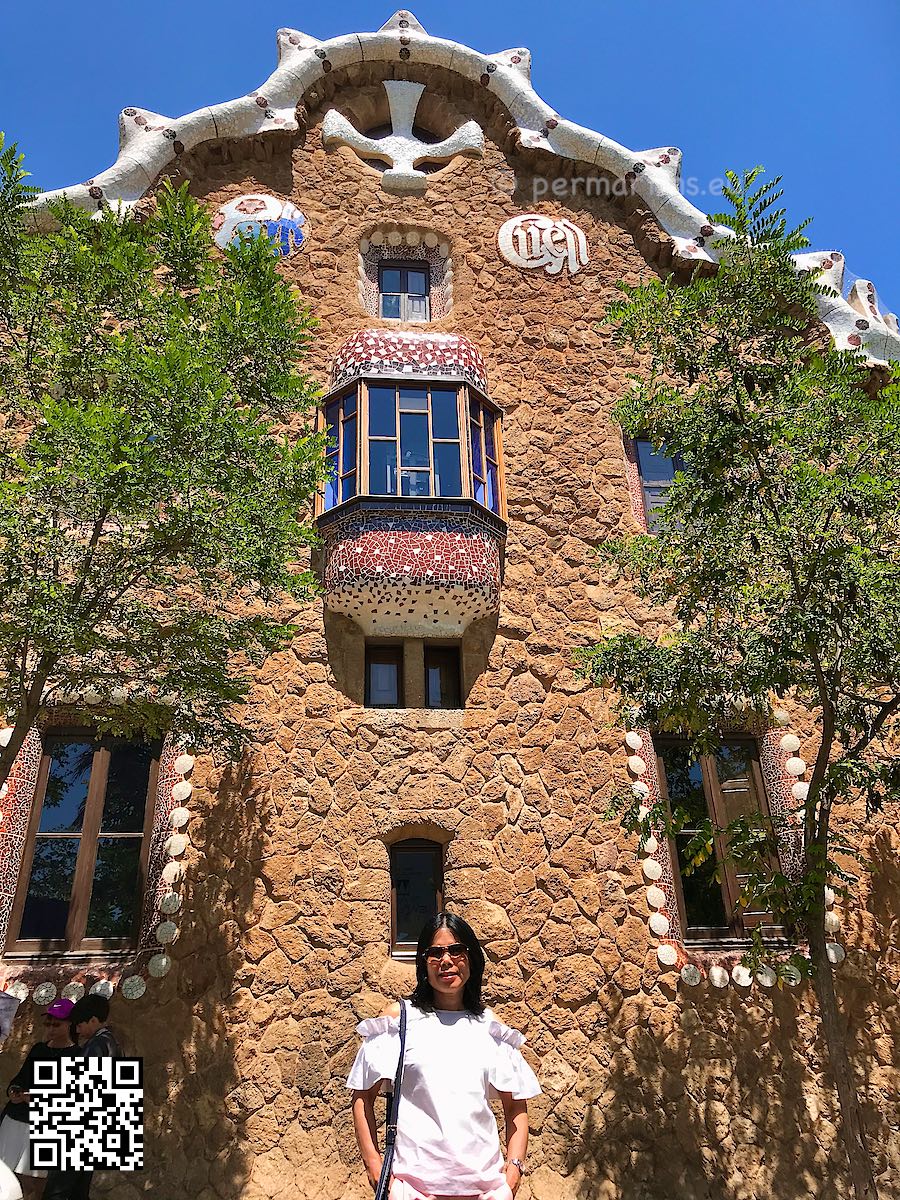 Spain Barcelona Parc Güell woman standing in front of Casa del Guarda by Antoni Gaud
