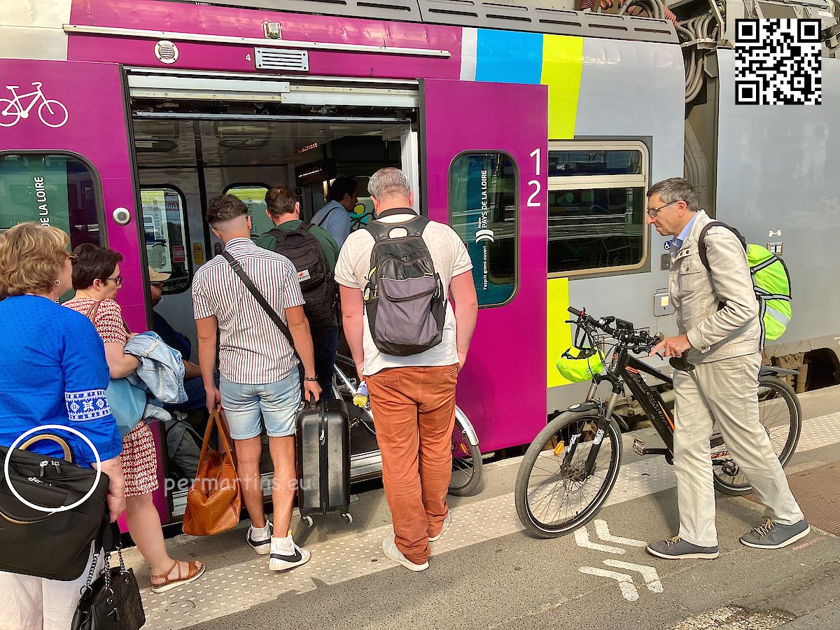 France people getting on a commuter train and a man with a bicycle