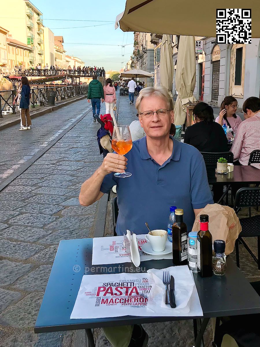 Italy Milano Navigli man holding a glass of Aperol Spritz at Bistro Monaco